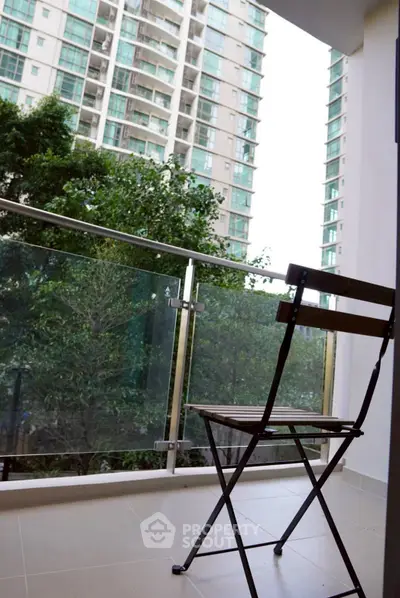 Charming balcony with modern glass railing and city view, perfect for relaxation and enjoying the outdoors.