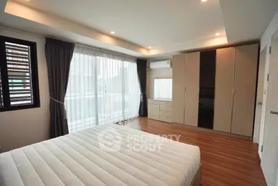 Spacious modern bedroom with large windows and ample storage in a stylish apartment.