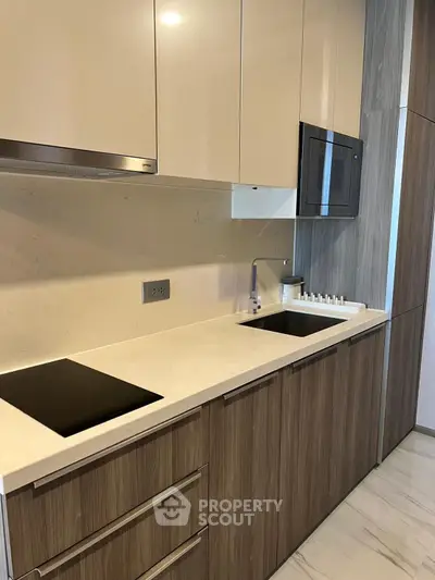 Modern kitchen with sleek cabinetry and built-in appliances, featuring a minimalist design and elegant finishes.