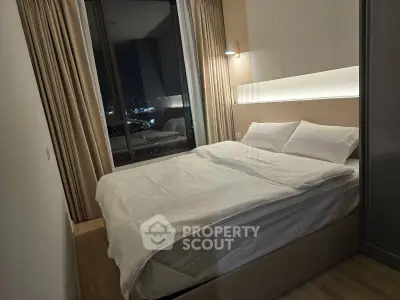 Modern bedroom with city view, featuring cozy bed and ambient lighting for a relaxing atmosphere.