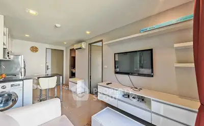 Modern living room with sleek furniture and built-in appliances in a stylish apartment.