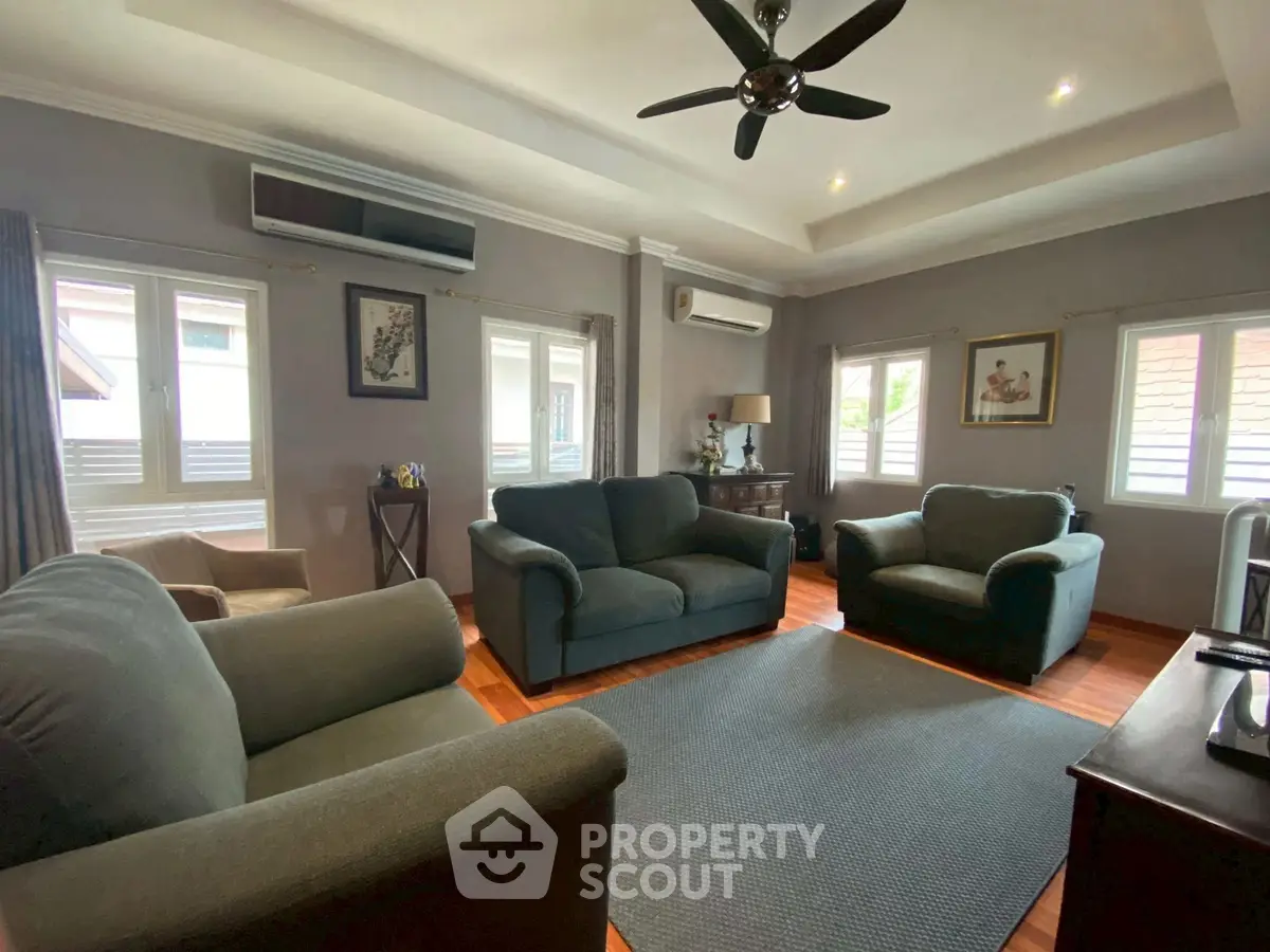 Cozy living room with plush sofas and natural light, perfect for relaxation.