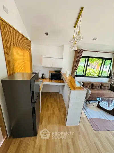 Modern open-layout kitchen and living room with stylish decor and natural light.