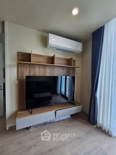 Modern living room with sleek TV unit and air conditioning, featuring elegant curtains and wooden flooring.