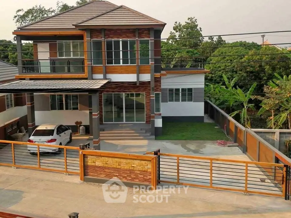 Modern two-story house with carport and lush garden in suburban setting.