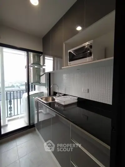 Modern kitchen with sleek cabinets and balcony view