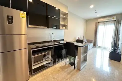 Modern open-layout kitchen with sleek appliances and cozy living area