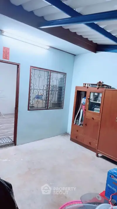 Cozy interior space with wooden cabinet and window, perfect for storage or small office setup.