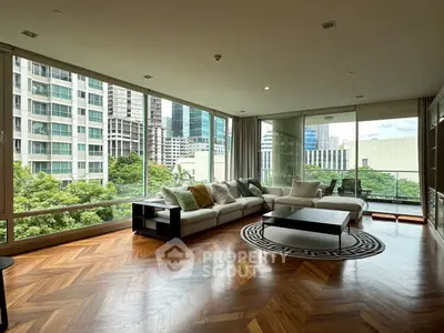 Luxurious living room with panoramic city view and elegant hardwood floors.