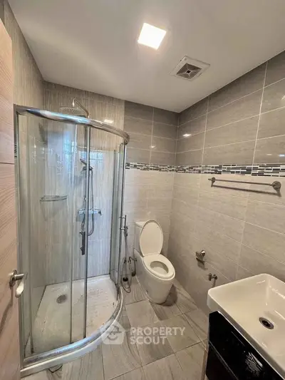 Modern bathroom with sleek shower and contemporary fixtures in a stylish apartment.