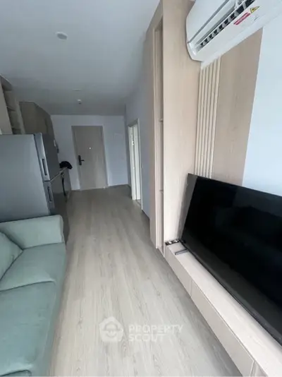Modern living room with sleek design, featuring a wall-mounted TV and air conditioning, perfect for urban living.
