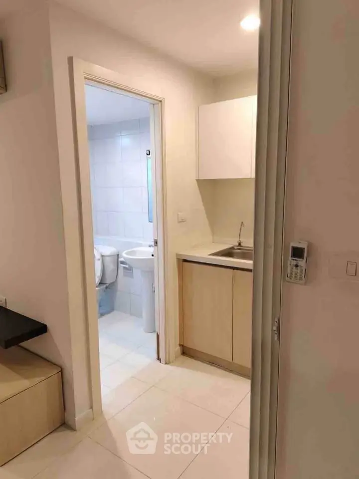 Compact bathroom and kitchenette in modern apartment with sleek design.