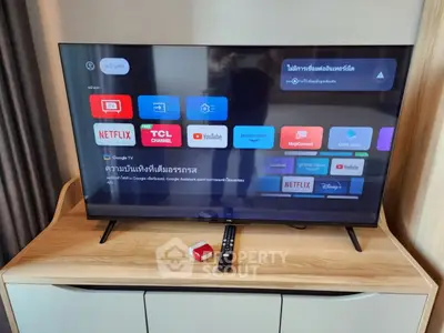 Modern living room with smart TV and wooden cabinet, perfect for entertainment enthusiasts.