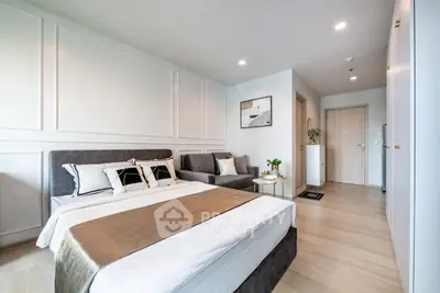 Modern bedroom with stylish decor and cozy seating area, perfect for relaxation and comfort.