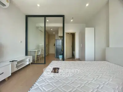 Modern studio apartment with glass partition and sleek furnishings