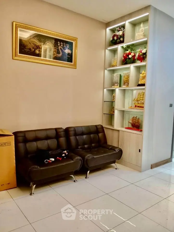 Modern living room with stylish black sofas and decorative shelving, perfect for cozy gatherings.