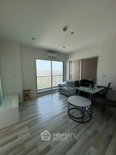 Modern living room with large windows and city view, featuring sleek furniture and stylish decor.