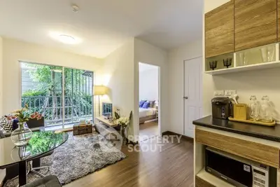 Modern living room with cozy decor and natural light, featuring a view of the garden through large windows.