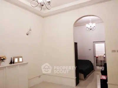 Spacious living area with elegant archway leading to cozy bedroom