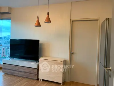 Modern living room with TV, stylish lighting, and city view.