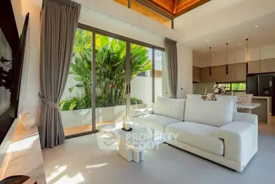 Luxurious living room with modern decor and large glass doors opening to a lush garden view.