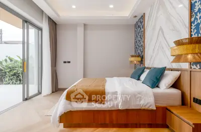 Luxurious bedroom with modern decor and large sliding glass doors opening to a garden view.
