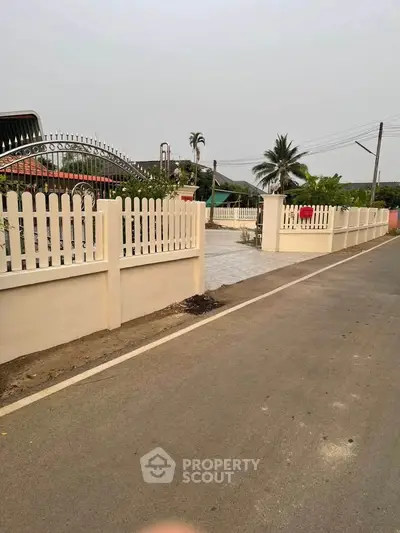Charming suburban property with white picket fence and spacious driveway.
