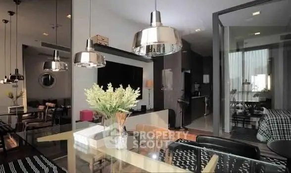 Modern open-plan living and dining area with stylish lighting and contemporary decor.