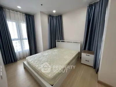 Modern bedroom with large windows and stylish curtains in a cozy apartment.