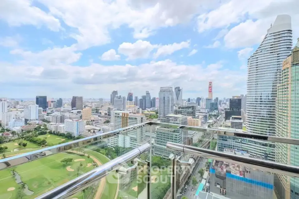 Stunning cityscape view from a high-rise balcony overlooking a golf course and skyline.