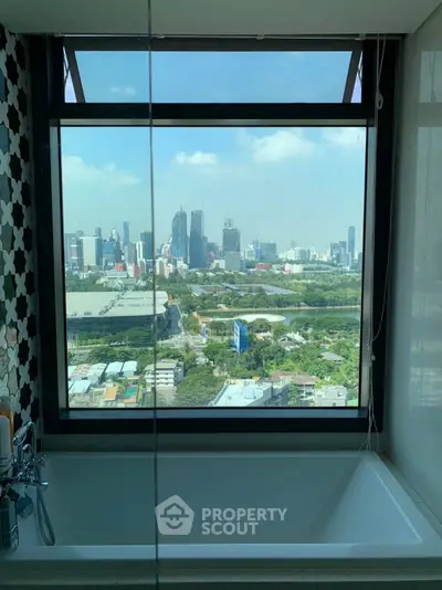 Luxurious bathroom with stunning city skyline view from large window.