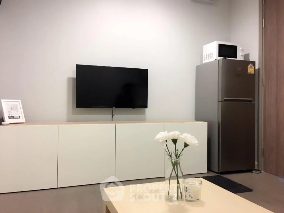 Modern living room with wall-mounted TV and sleek kitchen appliances