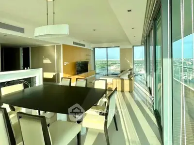Luxurious open-plan living room with panoramic city views and elegant dining area.