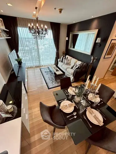 Luxurious living room with elegant decor and stunning city view, featuring a chic chandelier and modern furnishings.