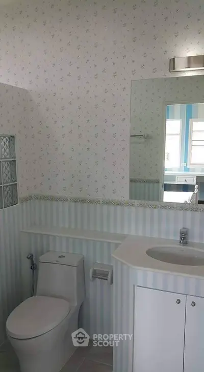 Charming bathroom with floral wallpaper and modern fixtures