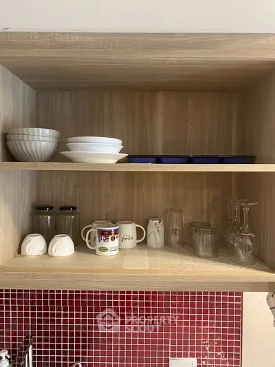 Modern kitchen with open wooden shelves displaying dishes and glasses, red tiled backsplash adds vibrant touch.