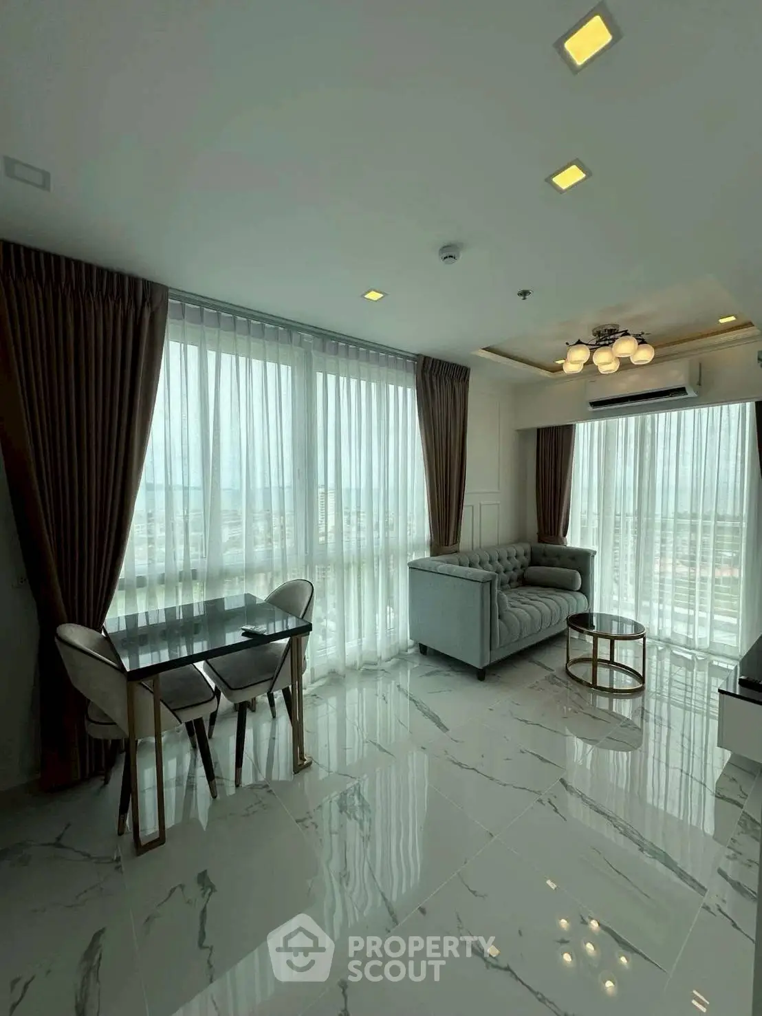 Luxurious modern living room with panoramic windows and elegant furnishings.