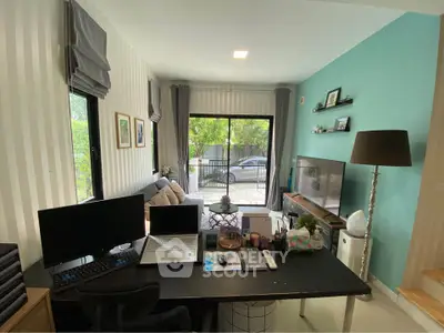 Modern living room with home office setup and large window view
