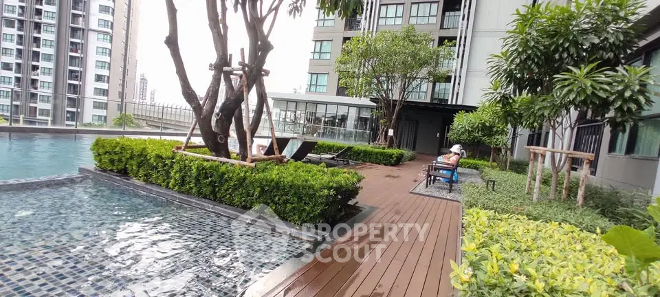 Luxurious rooftop pool area with lush greenery and modern design in a high-rise building.