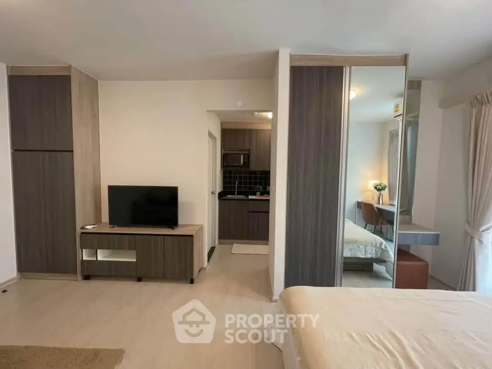 Modern studio apartment with open layout, featuring a cozy living area and compact kitchen.