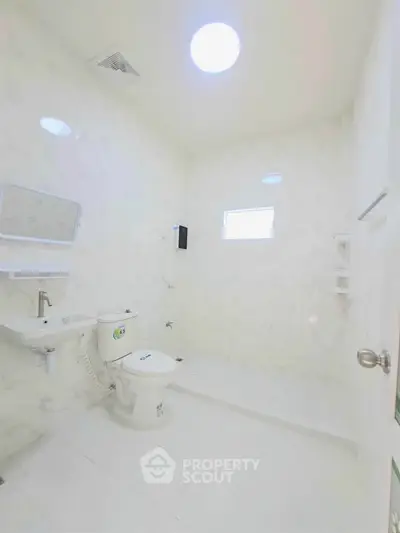 Bright and modern bathroom with sleek white fixtures and elegant marble walls.