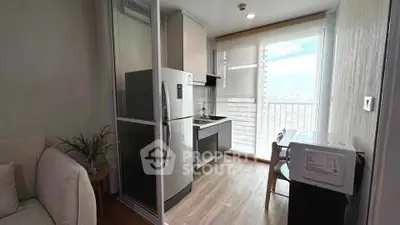 Modern compact kitchen with sleek appliances and bright natural light from large window.