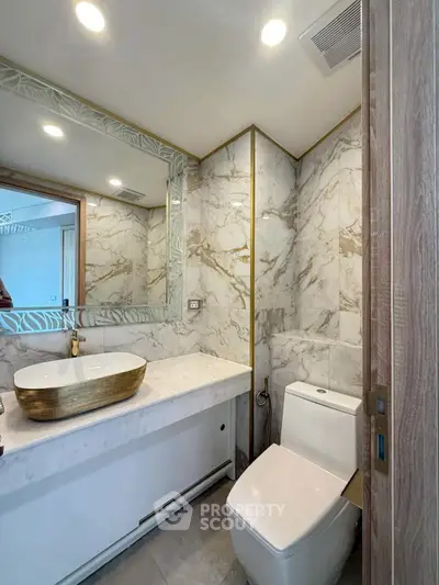 Luxurious bathroom with marble walls and modern fixtures in elegant real estate property.