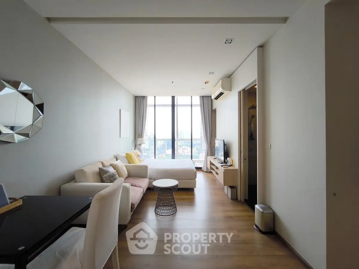 Modern living room with city view, stylish decor, and natural light