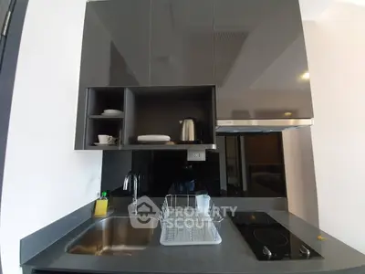 Modern kitchen with sleek cabinets and electric stove in compact layout