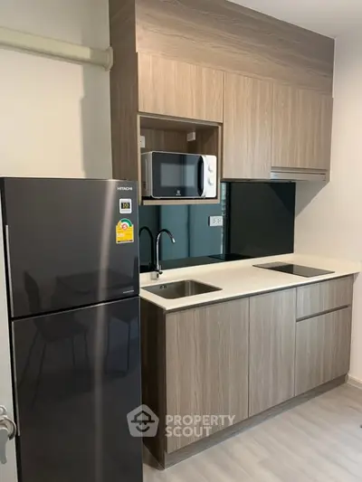 Modern kitchen with sleek cabinetry, double sink, and built-in microwave in a compact layout.