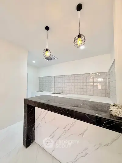 Modern kitchen with marble countertop and stylish pendant lights