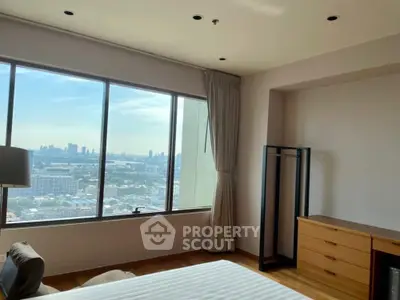 Spacious bedroom with panoramic city view and modern furnishings