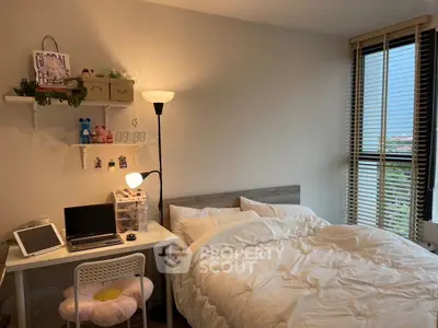 Cozy bedroom with modern decor and natural light, featuring a work desk and comfortable bed.