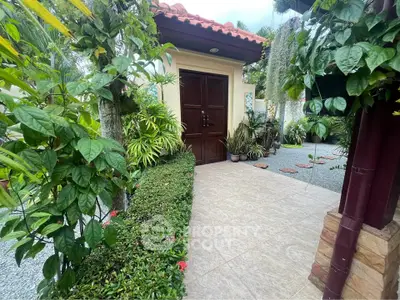 Charming garden entrance with lush greenery and elegant wooden door, perfect for a serene home ambiance.